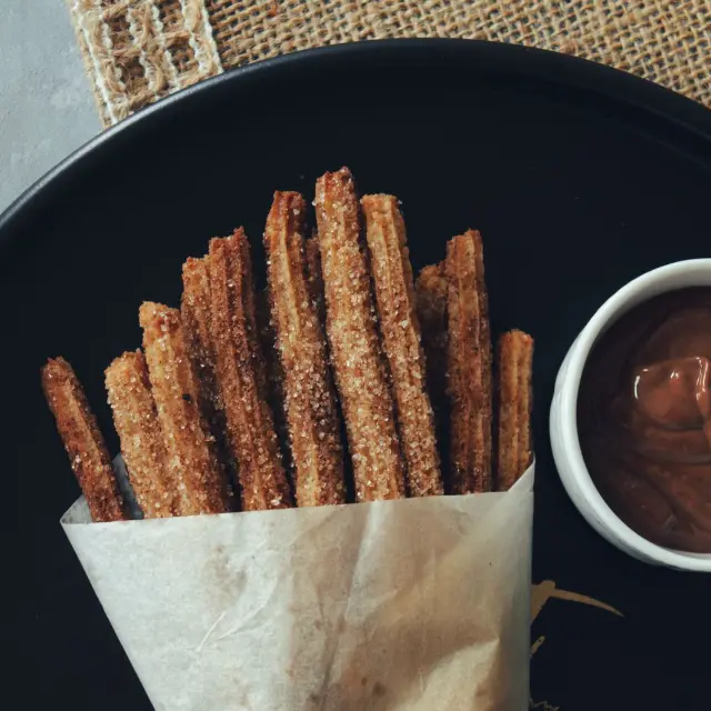 Cucurucho de churros con un cuenco de chocolate